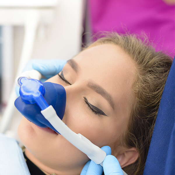 Woman in a dentist's chair with an oxygen mask